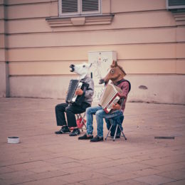 Hommes avec têtes de chevaux jouant de l'accordéon